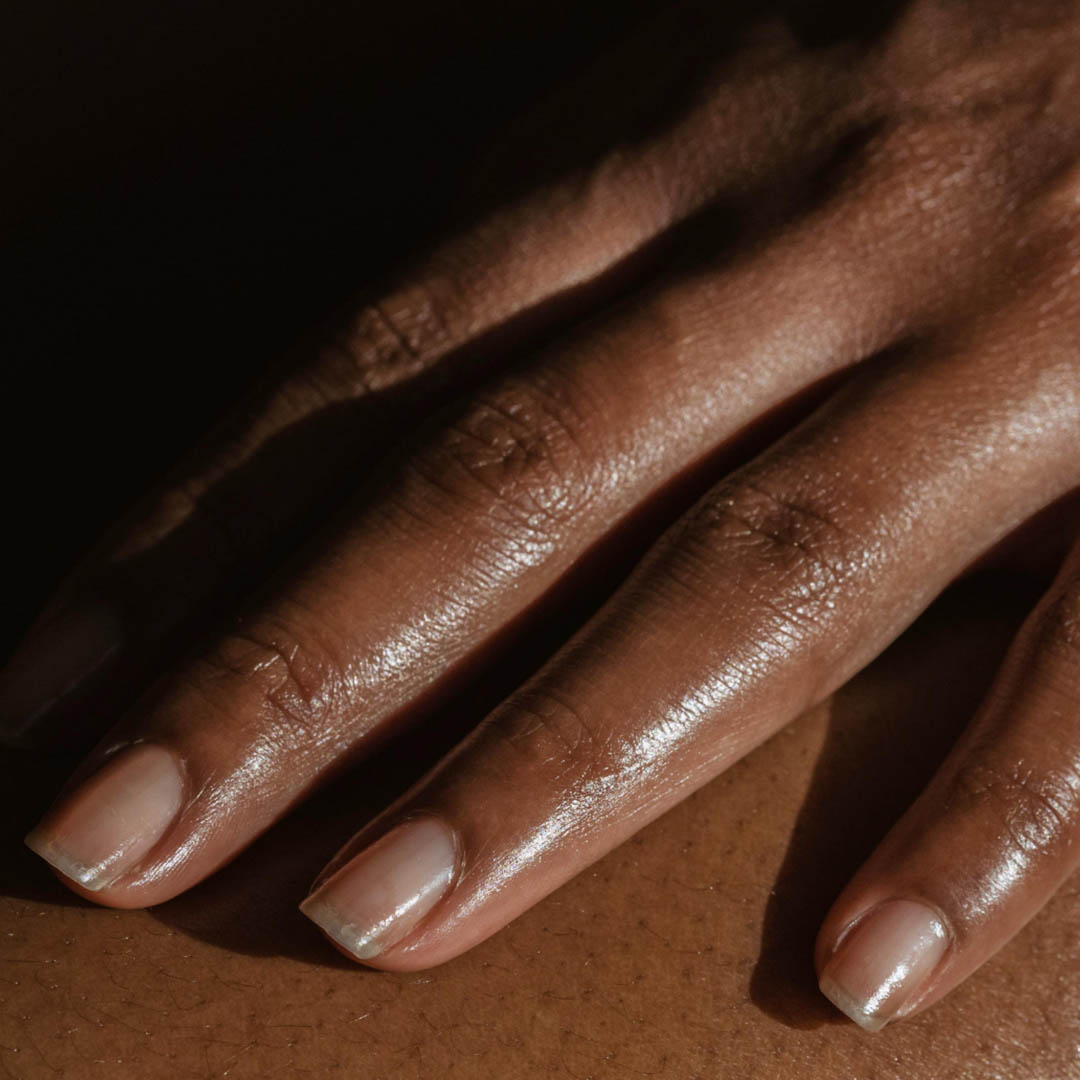 Nahaufnahme einer Hand mit natürlichen, sauberen Fingernägeln, die sanft auf einer Oberfläche ruht. Die Haut wirkt warm, glatt und gut befeuchtet, und subtile Licht- und Schatteneffekte verleihen dem Bild Tiefe. Nahaufnahme einer Hand mit natürlichen, sauberen Fingernägeln, die sanft auf einer Oberfläche ruht. Die Haut wirkt warm, glatt und gut befeuchtet, und subtile Licht- und Schatteneffekte verleihen dem Bild Tiefe.